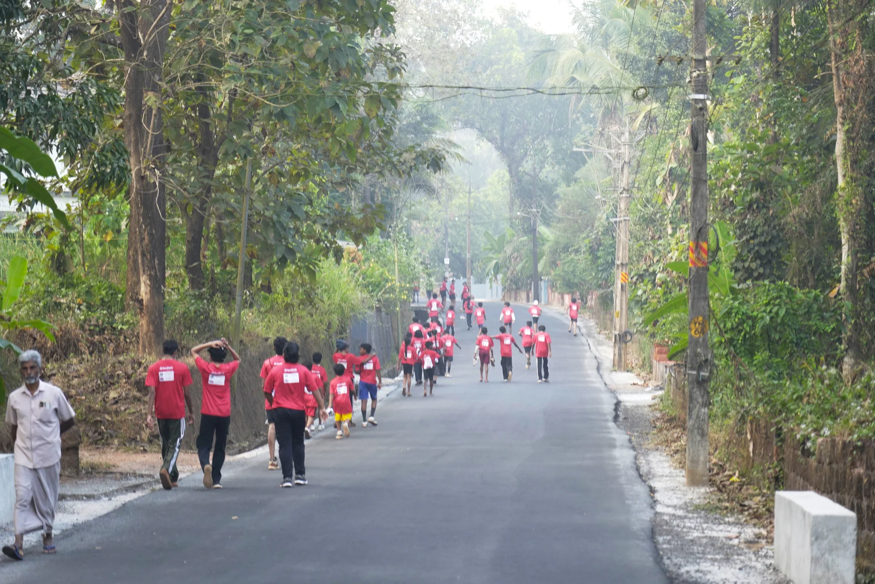 Marathon participants running through Peravoor's tree-lined hills