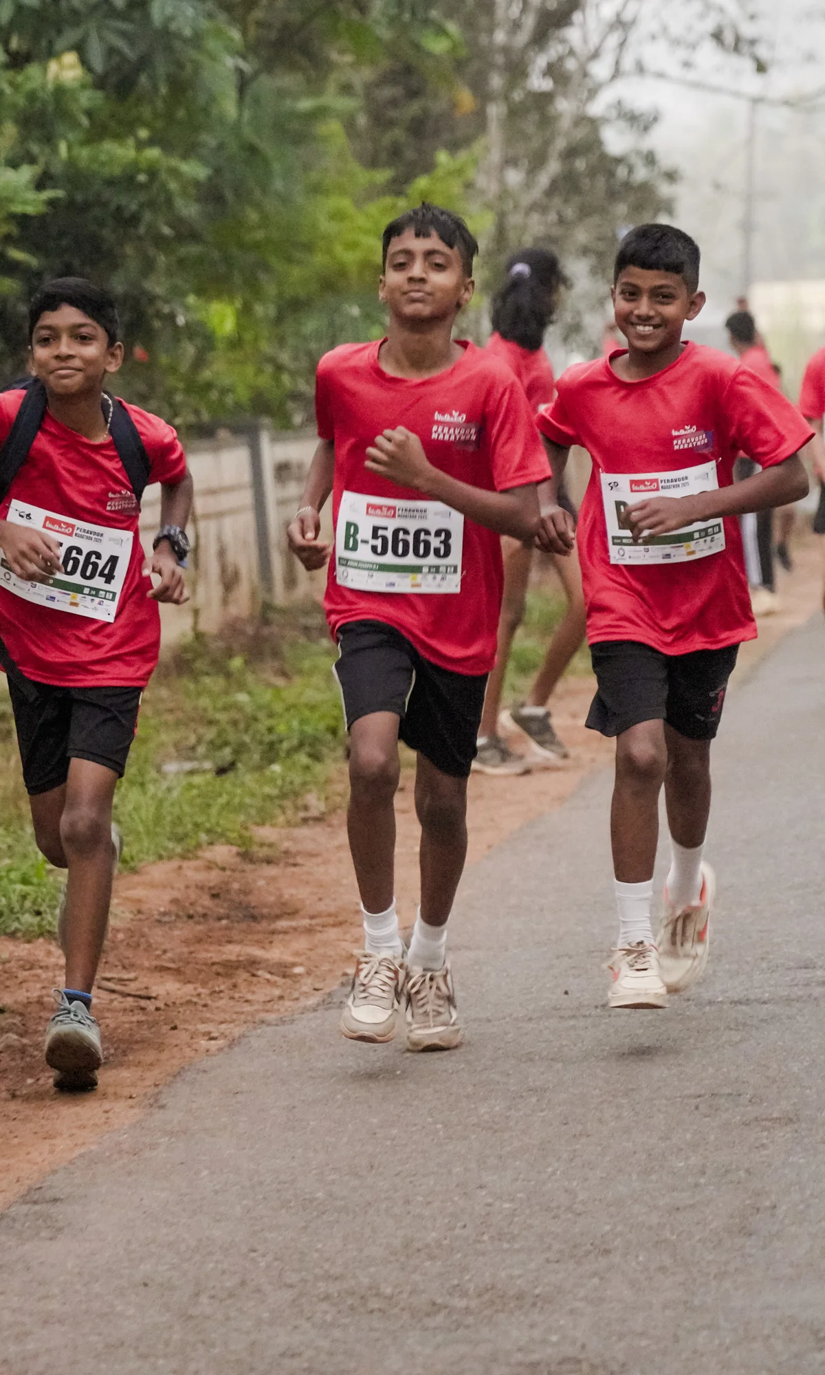 Three young runners on a green Peravoor road